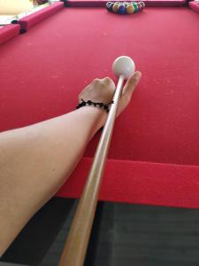 a person holding two cuesticks on a pool table at CHÁCARA VENEZA in São Roque