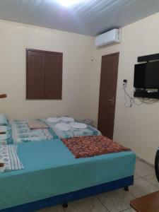 sypialnia z łóżkiem i telewizorem na ścianie w obiekcie casa em salinopolis w mieście Salinópolis