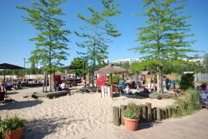 a beach with trees and people sitting in the sand at Apartment East Side in Berlin