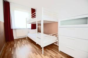 - une chambre avec des lits superposés blancs et une fenêtre dans l'établissement Apartment East Side, à Berlin