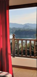 a room with a window with a view of the water at Hostal Balcones de la Piedra in Guatapé