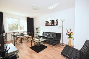 a living room with a black couch and a table at Apartment East Side in Berlin