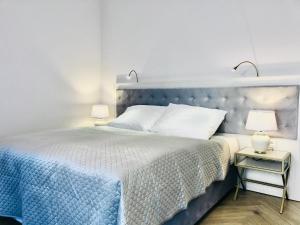 sypialnia z niebieskim łóżkiem i dwoma szafkami nocnymi w obiekcie Luxury Apartments in Residence Maritime w mieście Międzyzdroje
