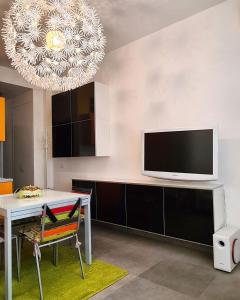 uma sala de estar com uma mesa de jantar e uma televisão em 27Apartment em Ancona