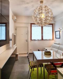 uma sala de estar com uma mesa e um lustre em 27Apartment em Ancona