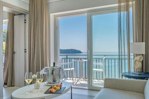 ein Zimmer mit einem Tisch mit Weingläsern und einem Balkon in der Unterkunft Summit Hotel in Gaeta