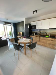 kuchnia i salon ze stołem i krzesłami w obiekcie MIĘDZYZDROJE,BALTICUS PROMENADA GWIAZD 14, Apartament z odrębnym salonem i sypialnią z Widokiem na morze w mieście Międzyzdroje