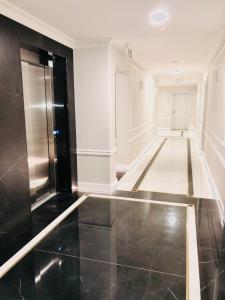 przedpokój z czarną podłogą wyłożoną kafelkami i lodówką w obiekcie Luxury Apartments in Residence Maritime w mieście Międzyzdroje