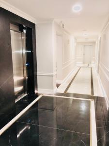 a hallway with a black tile floor and a refrigerator at Luxury Apartments in Residence Maritime in Międzyzdroje