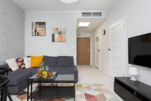 Una sala de estar con un sofá y un televisor en Business Center Apartments Warsaw Wola by Noclegi Renters, en Varsovia