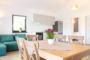 a kitchen and dining room with a table and a couch at Domki w porcie Zielony Gaj in Mikołajki