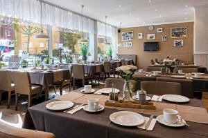 a restaurant with tables and chairs and a large window at Auto-Parkhotel in Hamburg