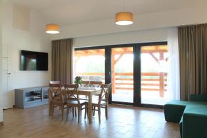 a living room with a table and chairs and a couch at Domki w porcie Zielony Gaj in Mikołajki