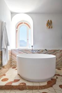 a bath tub sitting next to a window in a bathroom at Palazzo Avino in Ravello