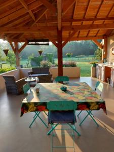 a table and chairs in a patio with a view at Le Moulin de l'Etang in Chaneins
