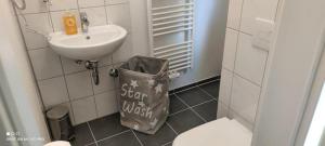 a bathroom with a sink and a trash can at Apartment Letter in Seelze