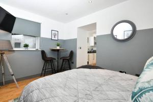 a bedroom with a bed and a mirror and a kitchen at Modern studio apartment in Leeds City Centre (LS1) in Leeds