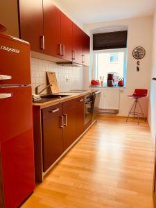 eine Küche mit braunen Schränken und Holzböden in der Unterkunft Moderne Wohnung in Eberswalde in Eberswalde-Finow