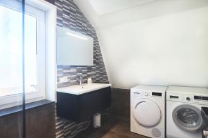 een badkamer met wastafel en wasmachine bij Apartment Bolwerkzicht in Middelburg