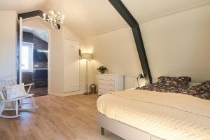 een slaapkamer met een bed, een tafel en een stoel bij Apartment Bolwerkzicht in Middelburg