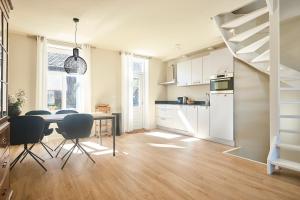 een keuken en eetkamer met een tafel en stoelen bij Apartment Bolwerkzicht in Middelburg