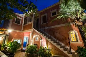 a building with stairs and a palm tree at night at Oasis in Preveza