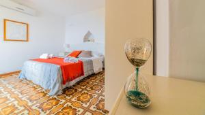 a bedroom with a bed and a glass vase on a table at Albergo Diffuso Bacco Furore in Furore