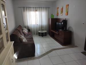 a living room with a couch and a tv at BRUNO KLEMTZ RUA 274 CaSA COM PISCINA PRIVATIVA in Itapema