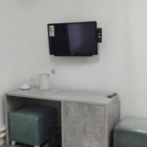 TV colgada en una pared con escritorio en Sulo Aksai Hotel, en Aksay
