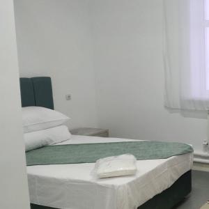 Aksay的住宿－Sulo Aksai Hotel，一间卧室配有两张带毛巾的床