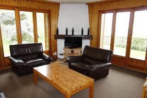 a living room with two leather chairs and a coffee table at Mélèzes R-S MOUNTAIN & SKI LIFT apartements in Veysonnaz