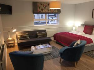 uma sala de estar com uma cama, um sofá e cadeiras em Hugh O'Neill Ambassador Suite em Dungannon
