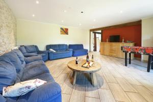 sala de estar con sofá azul y mesa en Le Clos Arboré (Gîte), en Libramont