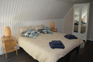 1 dormitorio con 1 cama con 2 toallas azules en Le Moulin de Chatillon, en Saint-Léger