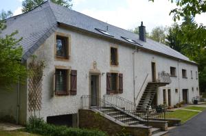 an old white house with stairs in front of it at Le Moulin de Chatillon in Saint-Léger