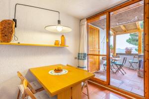 una cucina con tavolo e una sala da pranzo con finestra di Casa vacanze Cugnana Verde a Cugnana Verde
