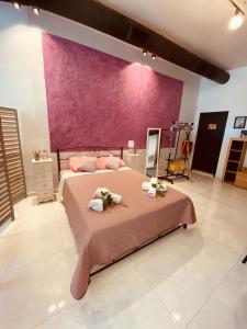 ein Schlafzimmer mit einem großen Bett mit einer lila Wand in der Unterkunft Corfu port apartment in Mantoúkion