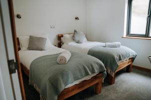 een slaapkamer met twee bedden met groene dekens erop bij Ty Melyn, Newgale in Newgale