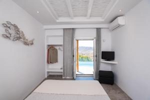 a room with a door leading to a pool at Mykonos Village in Ano Mera +121 photos