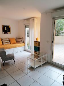 sala de estar con cama y mesa de cristal en Studio neuf 25 m2, terrasse 35 m2 proche port Nice, Centre ville en Niza