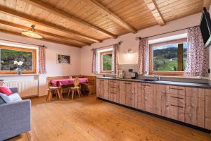 cocina con armarios de madera y mesa de comedor en Ferienwohnung Stockrose Nusserhof, en Avelengo