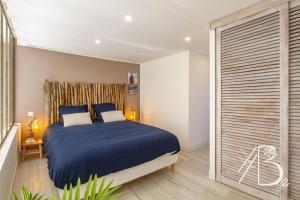 ein Schlafzimmer mit einem blauen Bett und einer Glasschiebetür in der Unterkunft Résidence de Porticcio youyoube2 in Porticcio