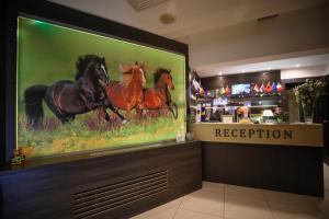 a store with a painting of horses on the wall at City Boutique Hotel in Sarajevo