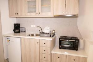 una pequeña cocina con fregadero y microondas en Traditional Myconian Studio in the heart of Chora en Mykonos