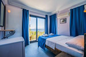 Un dormitorio con cortinas azules y una cama y una ventana. en Selim Pansiyon, en Kas