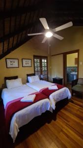 Schlafzimmer mit einem großen Bett und einem Deckenventilator in der Unterkunft Greenfire Hazyview Lodge in Hazyview