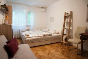 a bedroom with a bed and a desk and a chair at Studio Apartment Vijenac in Osijek