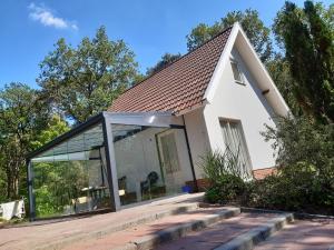 una casa con una gran ventana de cristal. en Vakantiewoning Zwaluw Beerze en Beerze