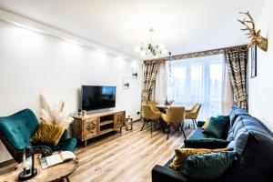 a living room with a blue couch and a tv at Apartament Diamentowy Odkryj Zakopane in Zakopane