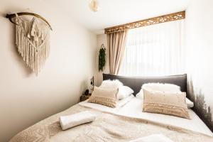 sypialnia z łóżkiem z białymi poduszkami i oknem w obiekcie Apartament Diamentowy Odkryj Zakopane w Zakopanem